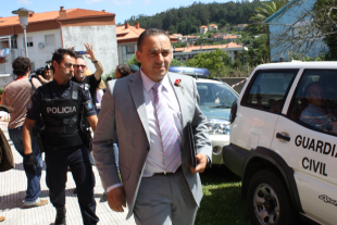 Un dos tr&aacute;nsfugas do PSOE escoltado &aacute; sa&iacute;da, con rosa vermella na chaqueta