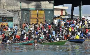 Habitantes da capital saen en chalanas para abordar un barco que os leve a Jeremie, localidade do norte de Hait&iacute; (clique para ampliar)