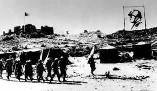 Tropas italianas marchan sobre Abisinia (Etiop&iacute;a) baixo un cartaz de Mussolini (clique para ampliar)