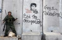 Un soldado israel&iacute; en Cisxordania discute con manifestantes polo ataque a Gaza (clique para ampliar)